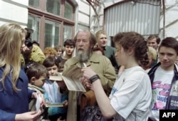 Russian writer Alexander Solzhenitsyn autographs his book "Archipelago GULAG" after meeting pupils of school number 1 in Vladivostok on May 30, 1994.