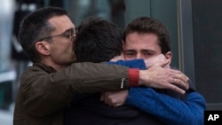 Family members of people involved in a crashed plane comfort each other as they arrive at the Barcelona airport in Spain, March 24, 2015. 