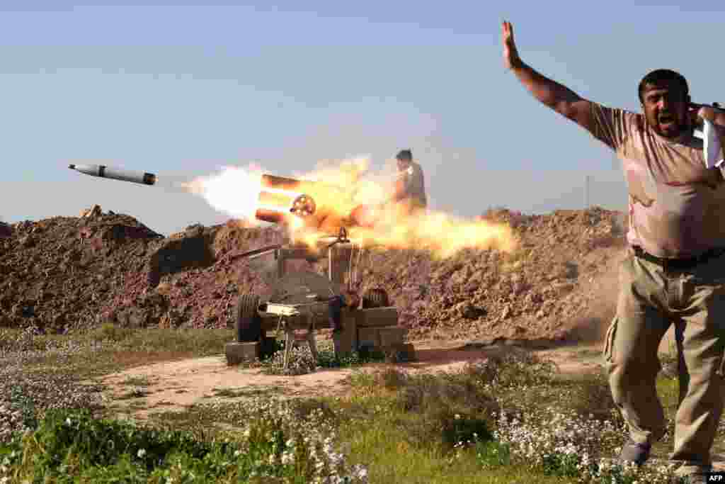 A fighter from the pro-government Popular Mobilisation units sets off a rocket launcher near the northern Iraqi city of Kirkuk. They are trying to recapture the nearby village of al-Bashir from Islamic State (IS) jihadists.