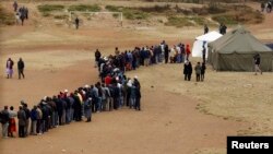 Zimbabweans wait in line to cast their votes in Mbare township outside Harare, July 31, 2013.