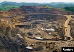 FILE - Excavators and drillers work in an open pit at a copper and cobalt mine in Congo's copper-producing south, Jan. 29, 2013.