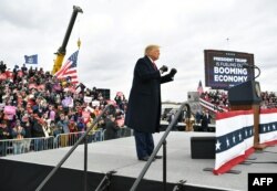 Президент Дональд Трамп проводит предвыборный митинг в аэропорту рядом с городом Уотерфорд-Тауншип, штат Мичиган