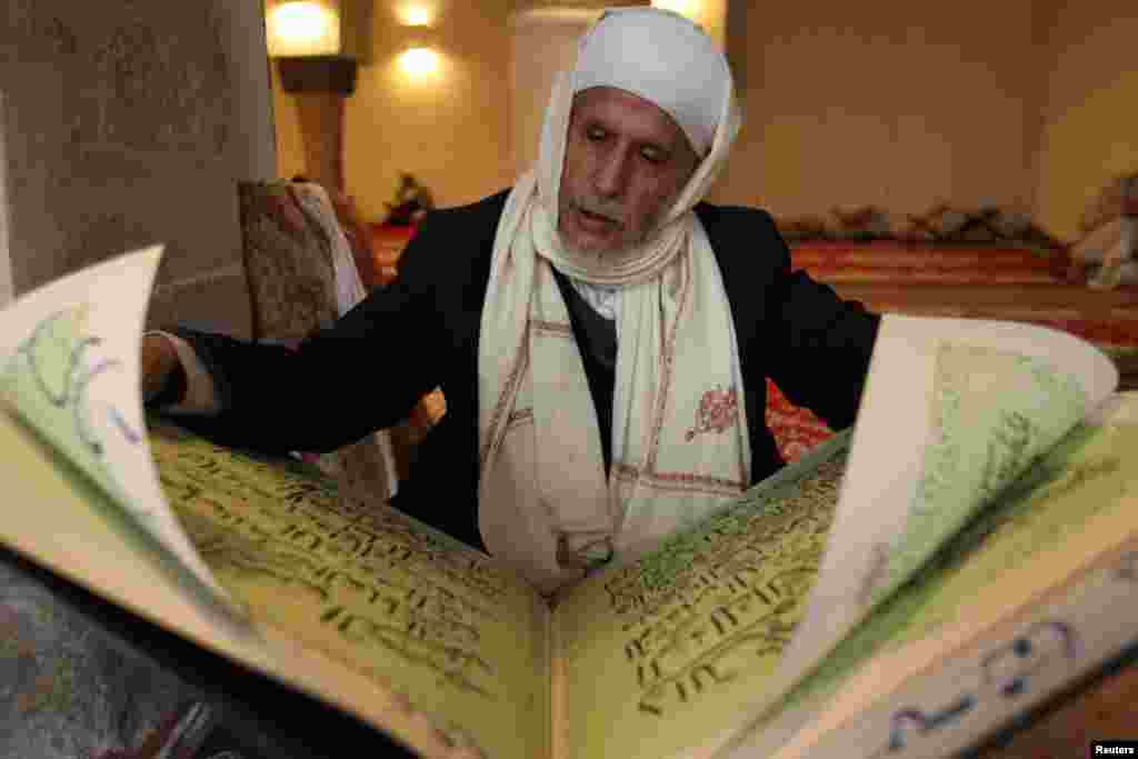 Seorang pria membaca Quran di sebuah masjid di Sanaa, Yaman (10/7). (Reuters/Mohamed al-Sayaghi)