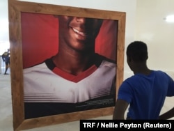 A teenager looks at his photograph displayed at the "Look at me" exhibition, Dakar, Senegal, May 11, 2018.