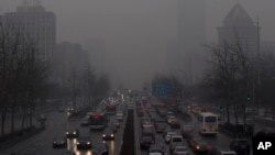 Endless lines of slow-moving cars emerge like apparitions and disappear into the gloom of the thick smog that has shrouded Beijing for weeks and reduced its skyline to blurry gray shapes, January 31, 2013.