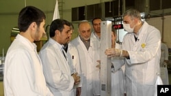 This photo released by the Iranian President's Office, claims to show Iranian President Mahmoud Ahmadinejad, second left being escorted by technicians during a tour of Tehran's research reactor center in northern Tehran, Iran, February 15, 2012.