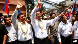 Cambodia's opposition leader Sam Rainsy, center, of the Cambodia National Rescue Party waves along with his party Vice President Kem Sokha, third from left, during a march in Phnom Penh, Cambodia, file photo. 