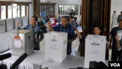 Presiden Susilo Bambang Yudhoyono, Ibu Negara Ani Yudhoyono dan putra bungsu mereka Edhie Baskoro Yudhoyono memasukkan kertas suara ke kotak suara. (VOA/Andylala Waluyo)