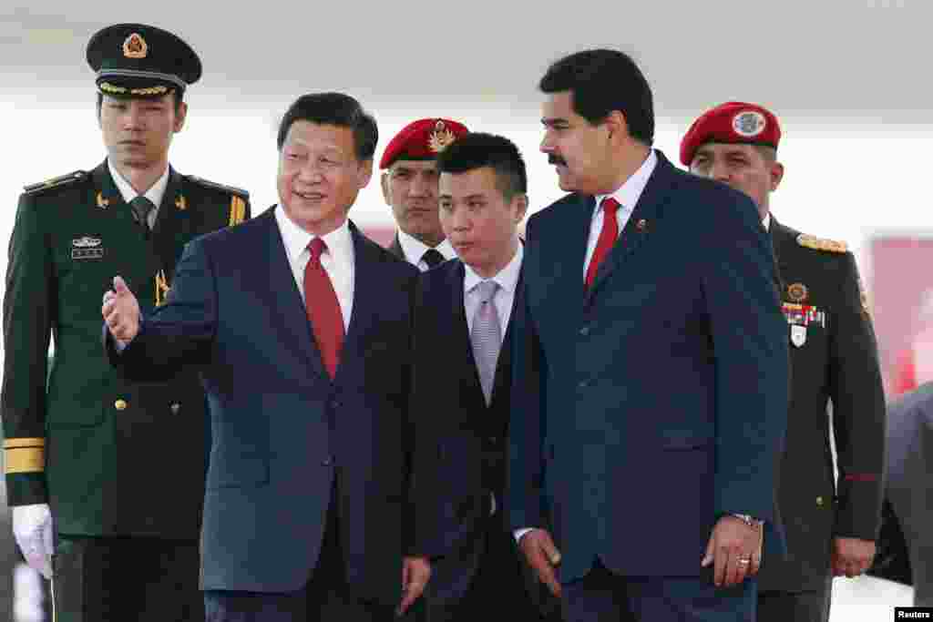 Chinese President Xi Jinping, second from left, gestures as he is welcomed by his Venezuelan counterpart Nicolas Maduro at the Simon Bolivar airport, in Caracas, July 20, 2014.