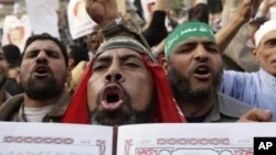 Supporters of President Mohamed Morsi chant slogans holding the Quran ahead of Egypt's controversial constitutional referendum, Cairo, December 14, 2012.