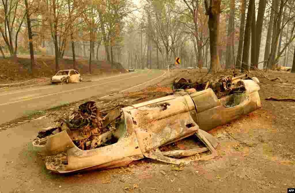 Burned cars litter a road during the Camp fire in Paradise, California 