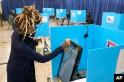 伊利诺伊州的选举工作人员擦拭电子投票机的屏幕