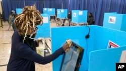 На фото: дезінфекція машини для голосування у штаті Іллінойс працівником дільниці