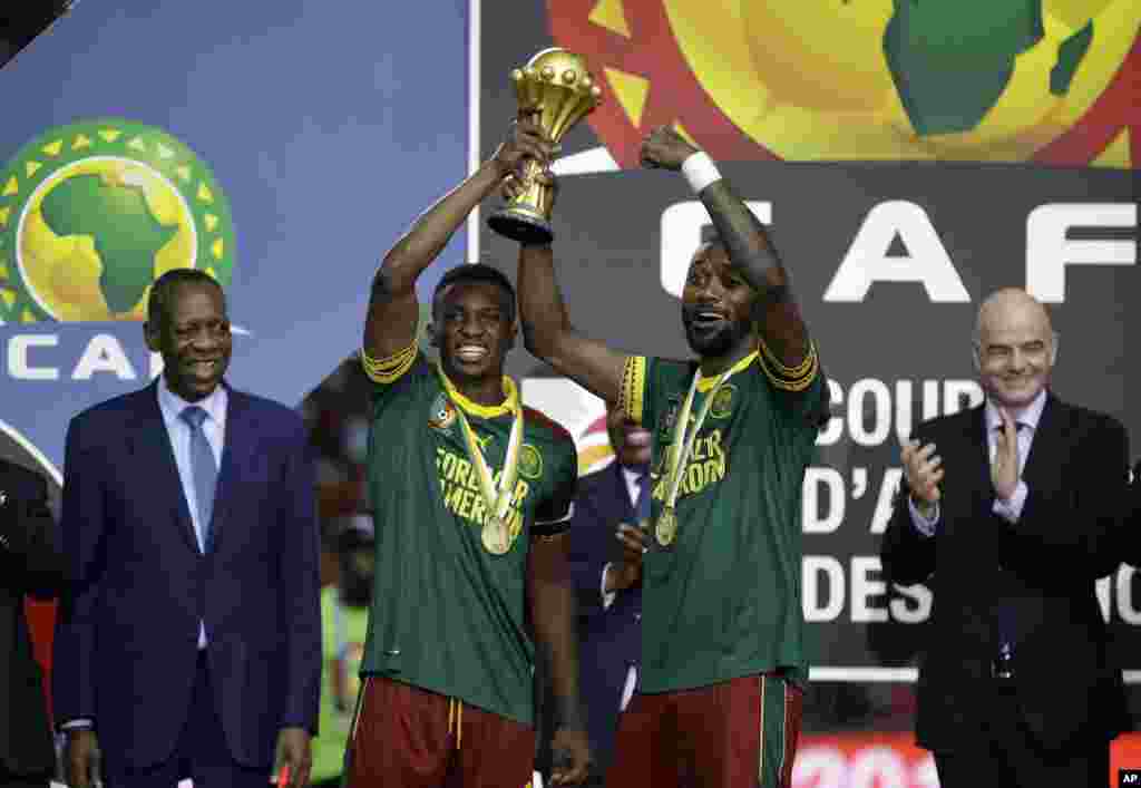 Benjamin Moukandjo, à esquerda e Nicolas Nkoulou com o troféu do CAN 2017, conquistado no Domingo 5 de Fevereiro em Libreville, Gabão.&nbsp;