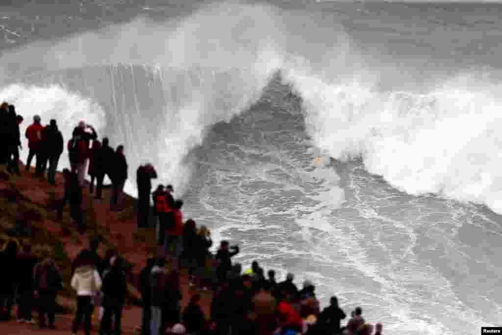 People gather to watch big waves at Praia do Norte in Nazare, Portugal.