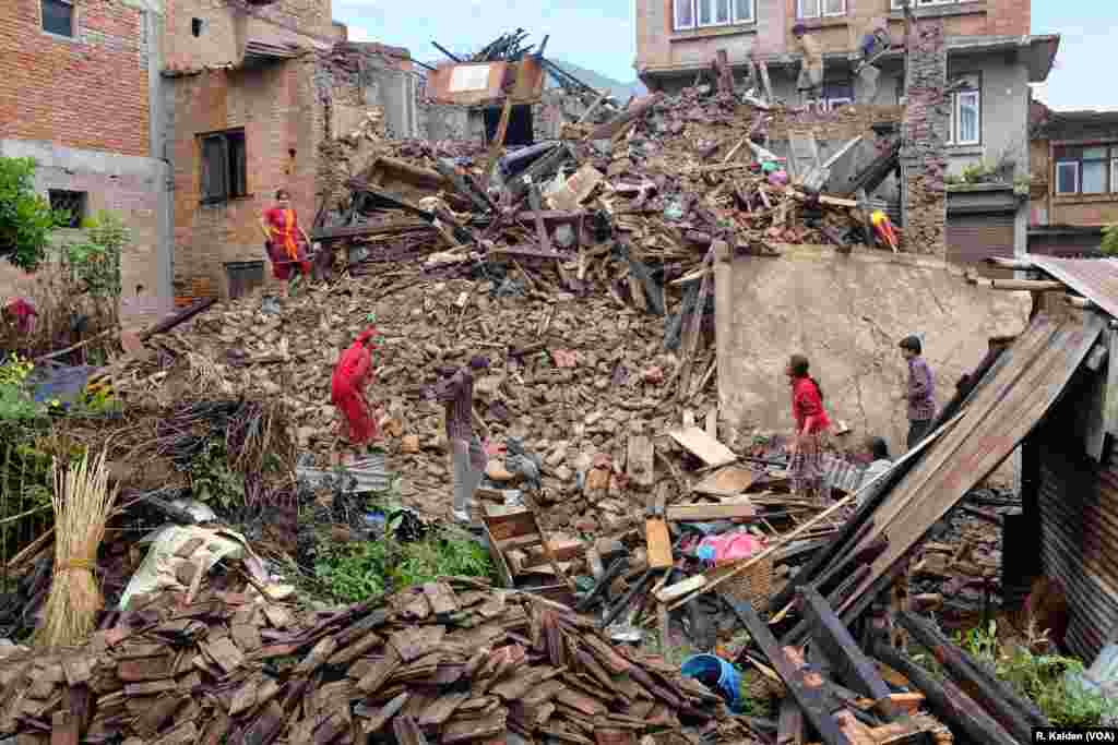 A family searches for any valuables they can find in their destroyed home, Sankhu, Nepal, April 29, 2015. (Rosyla Kalden/VOA)