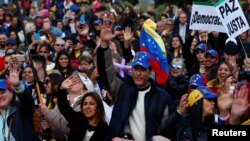 FILE - Protesters gather to call for humanitarian aid for Venezuela, in Madrid, Spain, Feb. 23, 2019.