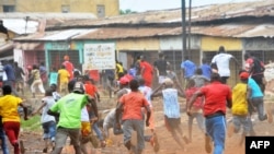 Des manifestants s'enfuient devant la police antiémeute dans un quartier de Conakry, le 21 novembre 2017.