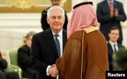 FILE - U.S. Secretary of State Rex Tillerson shakes hands with a participant as he attends a signing ceremony between U.S. President Donald Trump and Saudi Arabia's King Salman bin Abdulaziz Al Saud at the Royal Court in Riyadh, May 20, 2017.