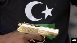A Libyan National Transitional Council (NTC) fighter holds a golden gun, marked in Arabic al-Jamahiyra (Gadhafi's people's republic) (File)
