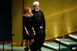 Iran's President Hassan Rouhani is escorted to address the Nelson Mandela Peace Summit in the United Nations General Assembly, at U.N. headquarters, Monday, Sept. 24, 2018.