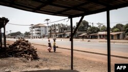 Deux femmes regardent debout dans une rue vide lors d'une manifestation dans le quartier populaire de Wanindara à Conakry le 27 février 2020.