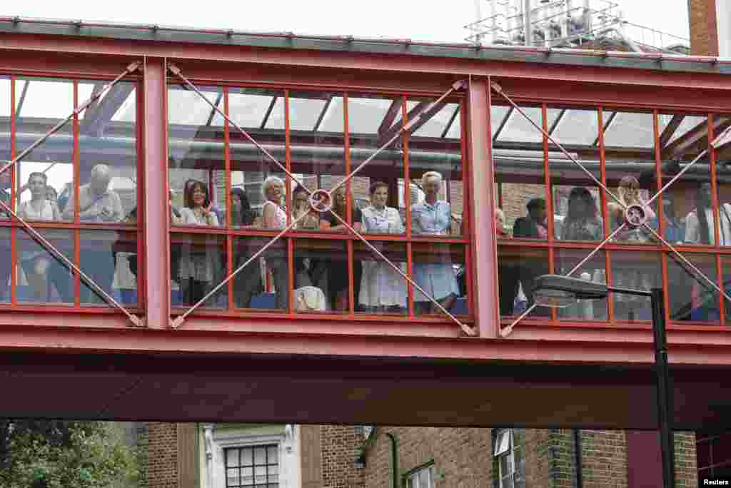 Funcionarios y visitantes en el Hotel St. Mary esperan la salida de los duques de Cambridge y el recién nacido príncipe de Cambridge.