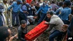 The coffin of one of those killed in the collapse of a mountain of trash at a garbage dump arrives for burial at the Gebrekristos church in Addis Ababa, Ethiopia, March 13, 2017.