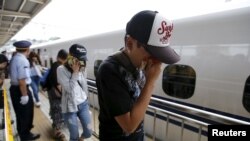 Passengers get off a Shinkansen bullet train at Odawara station after it made an emergency stop, in Odawara, west of Tokyo, June 30, 2015.