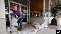Scott Youngblood moves sandbags into place in front of the furniture store Augustus & Carolina in Georgetown, S.C., Oct. 6, 2015. 