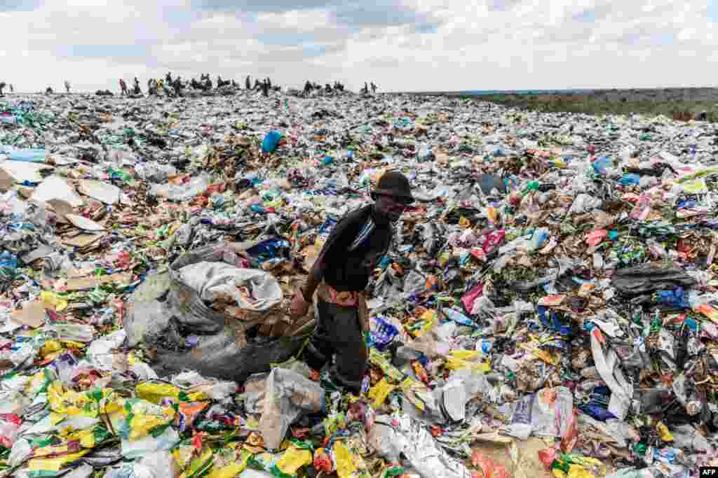 A man drags a huge bag of paper sorted for recycling past a heap of non-recyclable material at Richmond sanitary landfill site in the industrial city of Bulawayo, Zimbabwe.