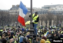 Protesters wearing yellow vests take part in a demonstration in Paris, Jan. 19, 2019.