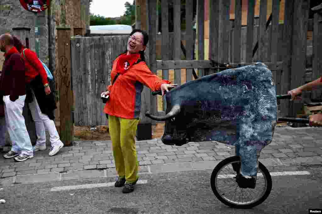 Một phụ nữ ngạc nhiên trước một chú bò giả tại Lễ hội Bò rượt San Fermin ở Pamplona, Tây Ban Nha.