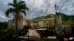 FILE - In this Sept. 8, 2018 file photo, a home that was abandoned after Hurricane Maria hit one year ago stands full of furniture in the San Lorenzo neighborhood of Morovis, Puerto Rico.