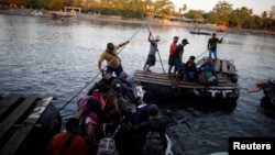FILE - People belonging to a caravan of migrants from Honduras en route to the United States cross the Suchiate River to Mexico from Tecun Uman, Guatemala, Jan. 18, 2019. 