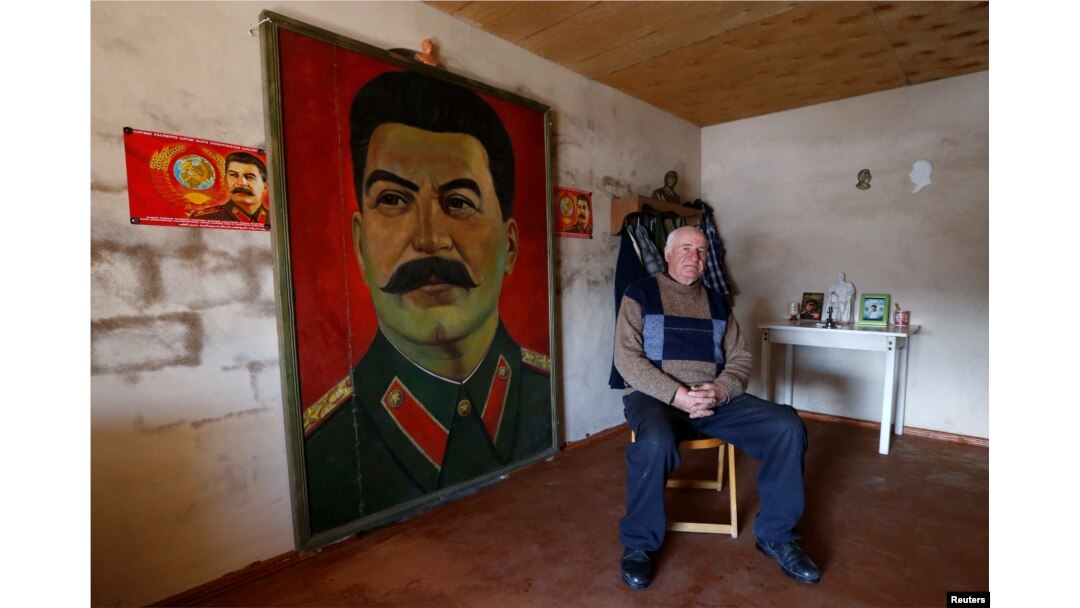 Retired builder Vasili Sidamonidze, 70, poses for a portrait at his home in Gori, Georgia, Dec. 6, 2016.