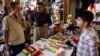 FILE - A bazaar vendor selling patriotic and pro-independence ware talks with a customer in Irbil, Iraq, Aug. 24, 2017. Despite calls from Baghdad and the United States to postpone the vote, Iraq’s semiautonomous Kurdish region is pressing ahead with plans to hold a referendum on independence Sept. 25.