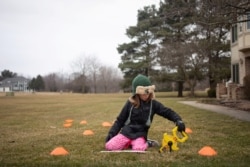 Molly Maguire, 8, measures the distance between cones during a math exercise learning how to calculate the area of different shapes in her front yard as schools are closed to combat the spread of coronavirus disease (COVID-19) in Salem Township