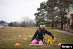 Molly Maguire, 8, measures the distance between cones during a math exercise learning how to calculate the area of different shapes in her front yard as schools are closed to combat the spread of coronavirus disease (COVID-19) in Salem Township