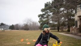 Molly Maguire, 8, measures the distance between cones during a math exercise learning how to calculate the area of different shapes in her front yard as schools are closed to combat the spread of coronavirus disease (COVID-19) in Salem Township