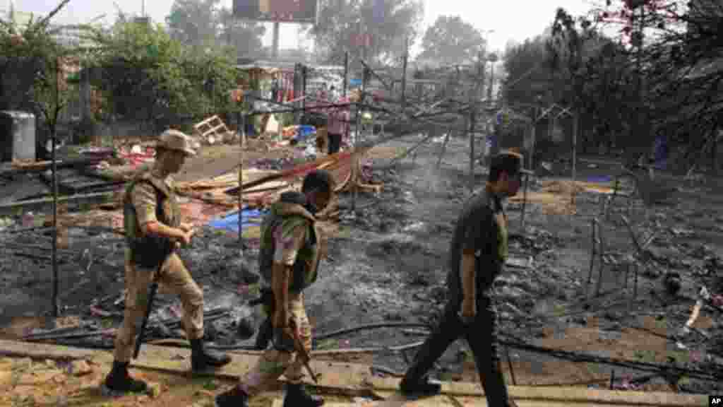 Members of the Egyptians Army walk among the smoldering remains of the largest protest camp of supporters of ousted President Morsi.