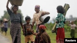 Rohingya Muslims carry their belongings as they move after recent violence in Sittwe, Burma, June 16, 2012. 