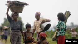 Kaum Muslim Rohingya memikul barang mereka saat mengungsi setelah aksi kekerasan di Sittwe (foto: dok Juni 2012).