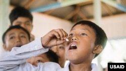 A student takes a dose of medication for lymphatic filariasis during a mass drug administration campaign in South Sumatra, Indonesia. (File)