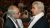 Riad Seif, right, architect of Syria's new opposition National Coalition, greets outgoing Syrian National Council chief Abdel Basset Seida (left) whose expatriate coalition accepted one-third of voting seats. Nov. 6, 2012. (AP) 