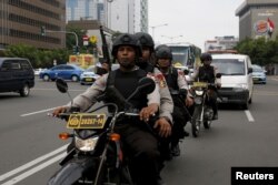 Indonesian policemen ride motorcycles as they patrol near the bomb blast site at Thamrin business district in Jakarta, Jan. 15, 2016.