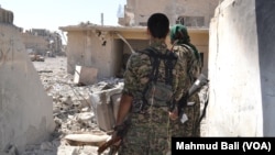 미군이 지원하는 시리아민주군(SDF)이 지난 23일 시리아 락까의 무너진 건물터를 순찰하고 있다. 