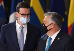 Poland's Prime Minister Mateusz Morawiecki, left, speaks with Hungary's Prime Minister Viktor Orban as they pose for a family photograph with EU leaders on the first day of a European Union summit at The European Council Building in Brussels, October 21,