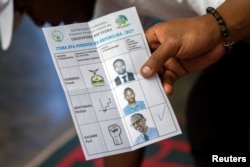 A polling staff member counts ballots at a polling center in Kigali, Rwanda, Aug. 4, 2017.