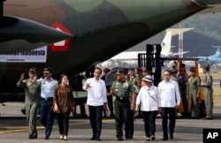 FILE - Indonesia President Joko Widodo, center, talks with Indonesian Army Chief of Staff Gen. Gatot Nurmantyo, during inspection of aids for Rohingya before its departure at Halim Perdanakusuma air base in Jakarta, Sept. 13, 2017.